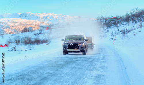 SUV rides on a winter forest road - A car in a snow-covered road among trees and snow hills