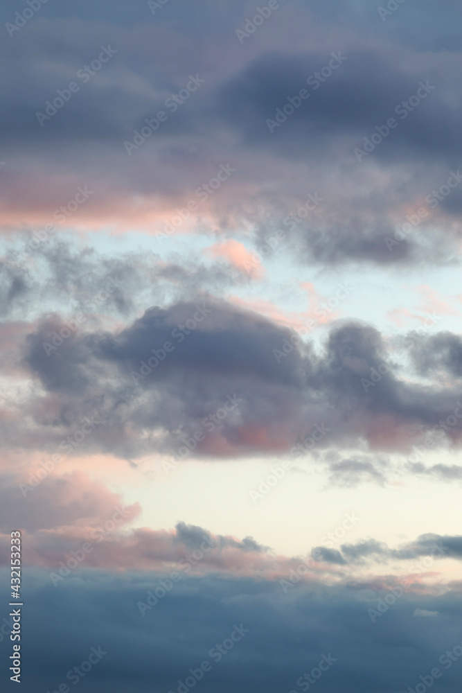 Beautiful evening sky with multi-colored bright clouds. Vertical photography.