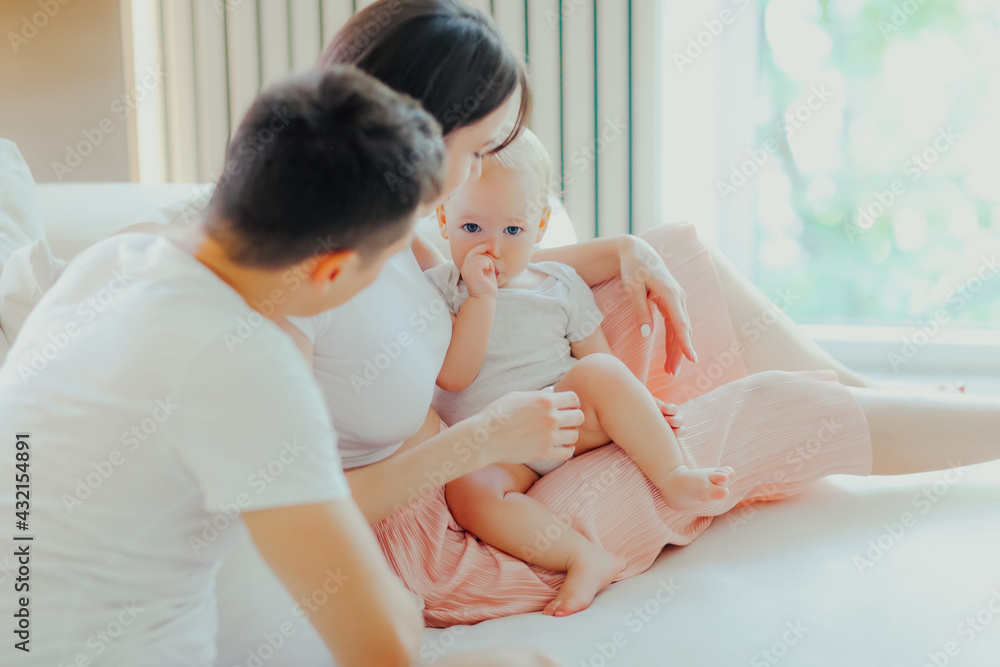 Father, mother and little son are relaxing on sofa in living room Father, mother and little son are relaxing on sofa in living room