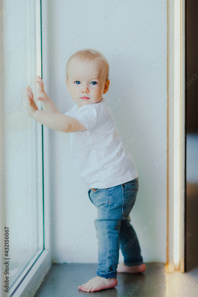 Small baby stands by window Small baby stands by window