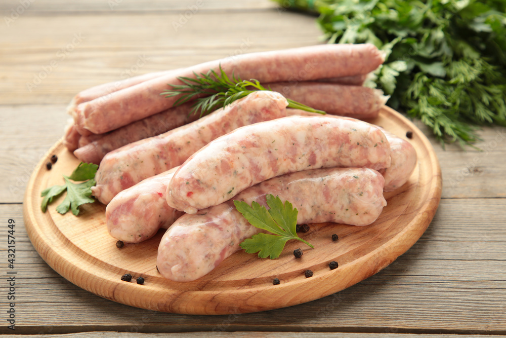 Raw sausage on cutting board on grey wooden background. Top view Raw sausage on cutting board on grey wooden background. Top view