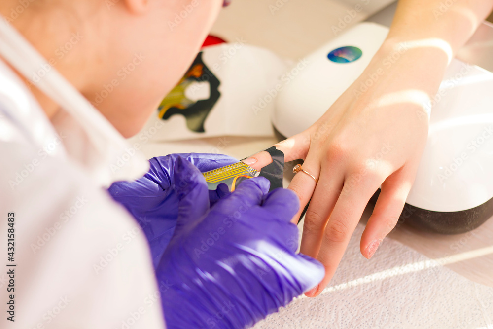 Naklejka premium Girl master makes hardware manicure with long-term coating