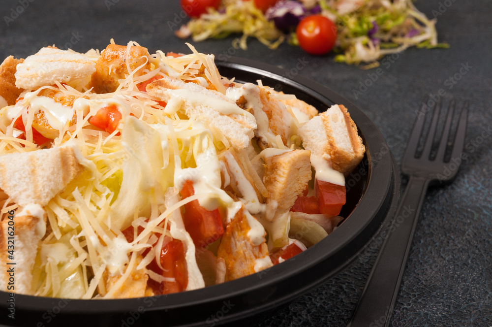 Caesar salad in a black bowl. close up Caesar salad in a black bowl. close up