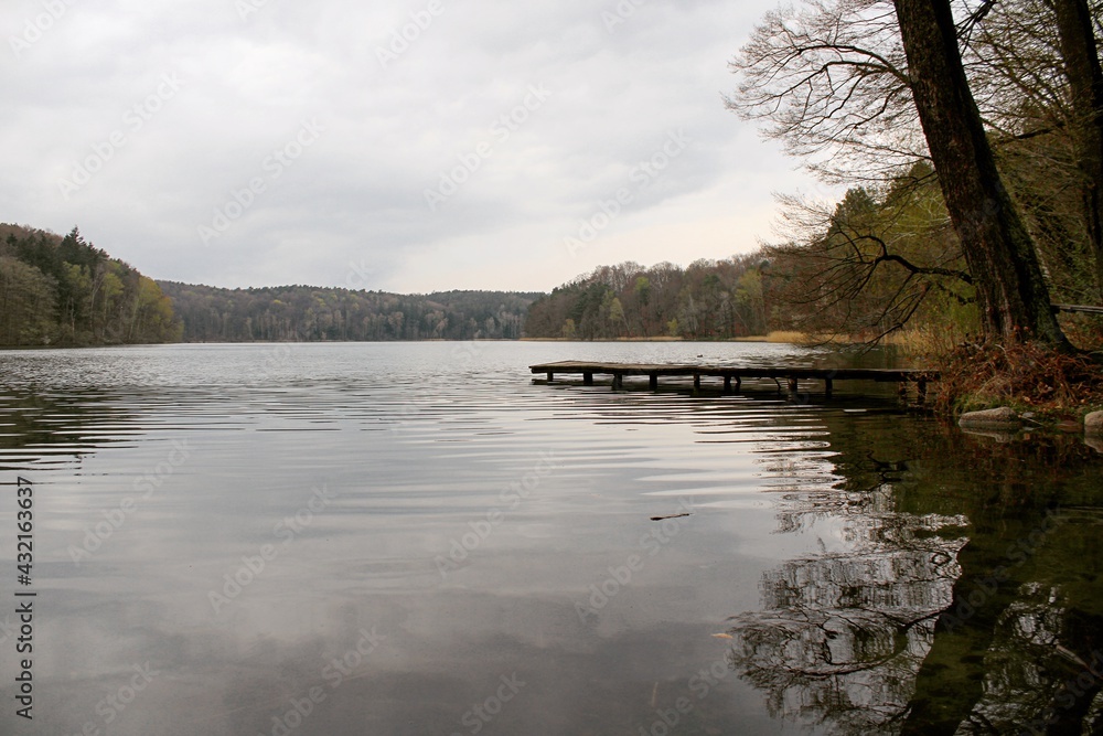 Naklejka premium Lake with a pier on a cloudly day