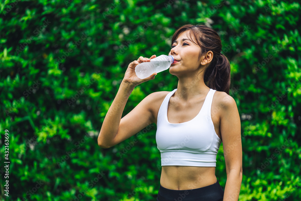Asian woman wearing tight exercise clothes drinking water Asian woman wearing tight exercise clothes drinking water