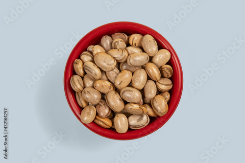 Fototapeta Naklejka Na Ścianę i Meble -  Dry pinto bean seed in red plastic bowl