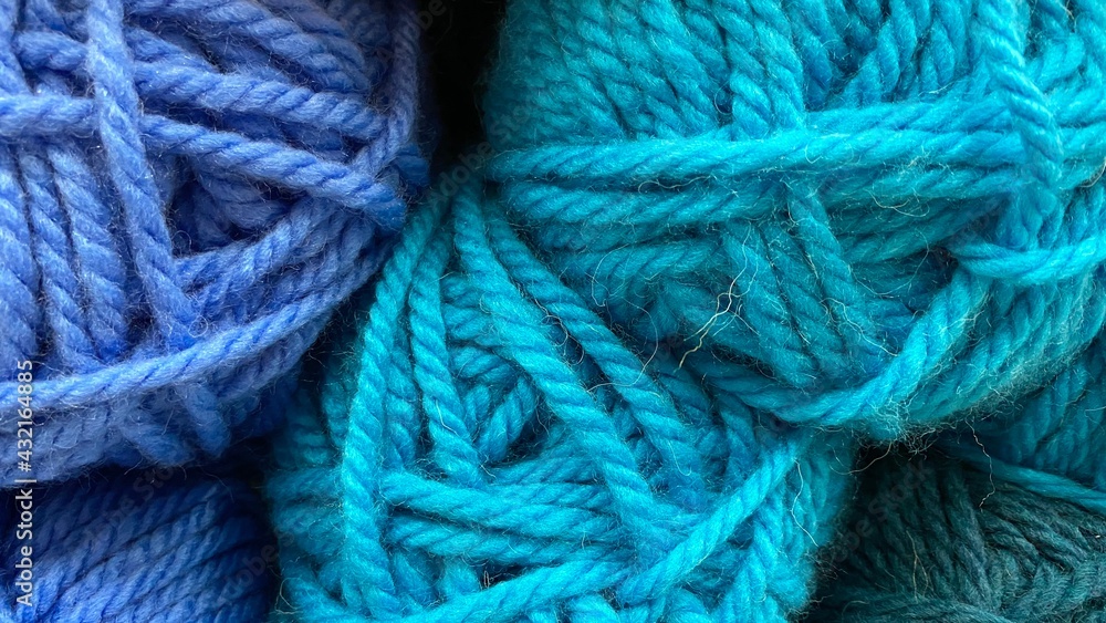 Blue and dark blue range of wool yarn. Multicolored skeins of wool close-up