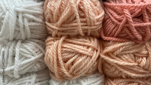 beige, pink and white range of wool yarn. Multicolored skeins of wool close-up