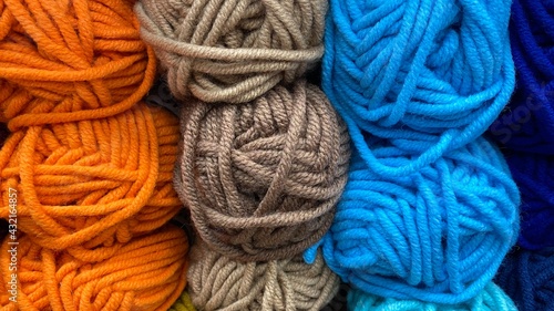 Blue, orange and brown range of wool yarn. Multicolored skeins of wool close-up