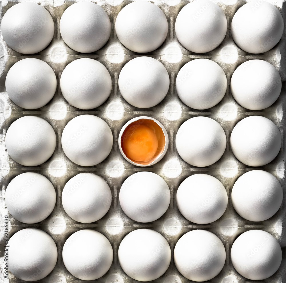 Open Egg with Yolk Stand Out from White Eggs Crowd. Flat Lay Top Down Abstract Patter food Image Open Egg with Yolk Stand Out from White Eggs Crowd. Flat Lay Top Down Abstract Patter food Image