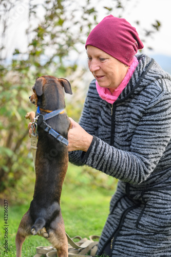 Aged woman on a walk with her dog.