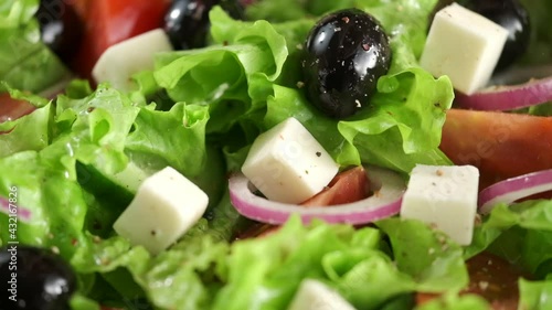 Greek salad of fresh cucumber, tomato, lettuce, red onion, feta cheese and olives with olive oil.