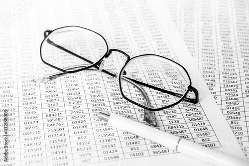 finance business calculation with glasses  tables with numbers and pen. business concept. financial literacy. accounting of income and expenses