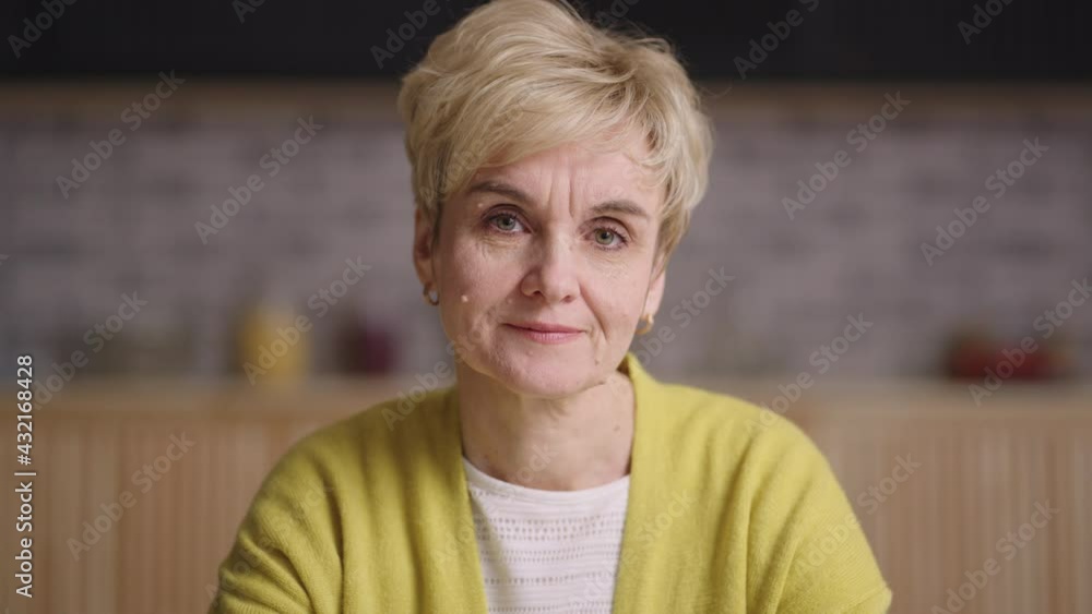 serious retiree lady is looking at camera, emotional portrait of old woman in apartment, online video chat concept serious retiree lady is looking at camera, emotional portrait of old woman in apartment, online video chat concept