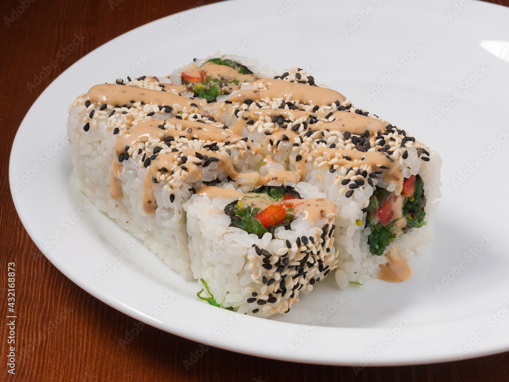 sushi roll with Chuka seaweed on a white plate sushi roll with Chuka seaweed on a white plate