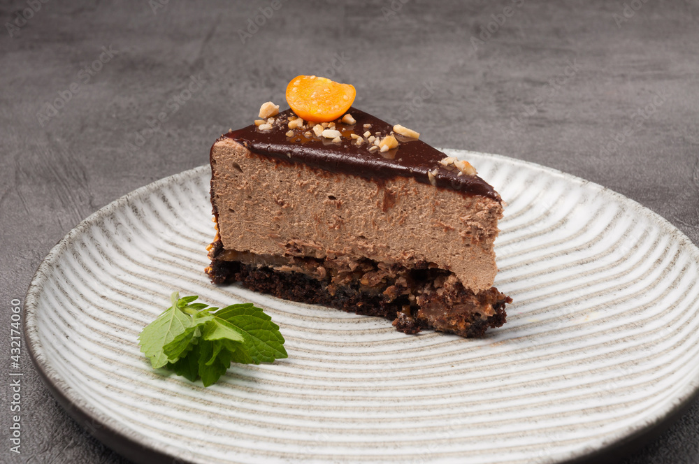 a piece of cake with chocolate mousse decorated with physalis and mint