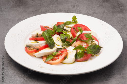 Caprese salad with tomatoes and mozzarella on a white plate