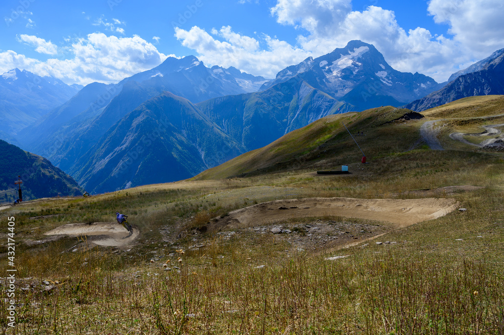 Hiking near ski station Les deux Alpes and view on Alpine mountains peaks in summer, Isere, France