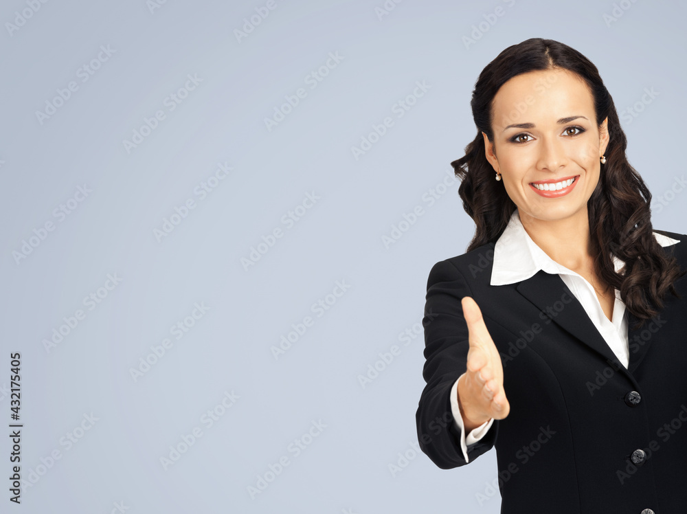 Happy smiling young beautiful business woman in black confident suit and white blouse, giving hand for handshake, isolated over grey color background with copy space. Happy smiling young beautiful business woman in black confident suit and white blouse, giving hand for handshake, isolated over grey color background with copy space.