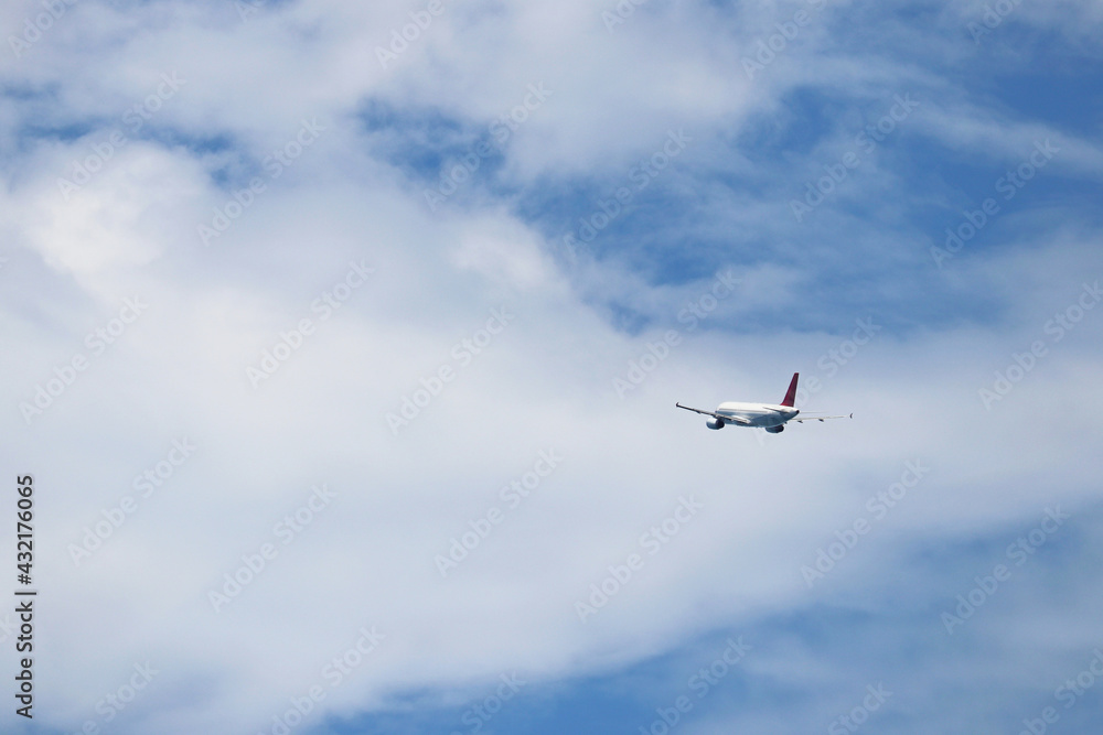 Airplane flying in the blue sky on background of white clouds, rear view. Twin-engine commercial plane during the turn, turbulence and travel concept Airplane flying in the blue sky on background of white clouds, rear view. Twin-engine commercial plane during the turn, turbulence and travel concept
