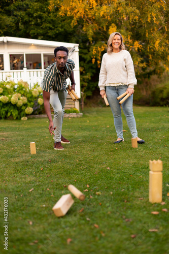 Man and woman playing molkky game in park photo