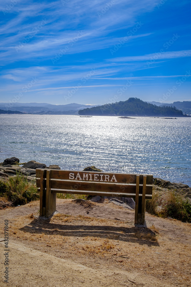 Wooden bench with the name of the place where it is located, on the beach of Samieira in the Rias Baixas, Galicia (Spain)