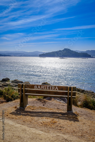 Wooden bench with the name of the place where it is located, on the beach of Samieira in the Rias Baixas, Galicia (Spain)