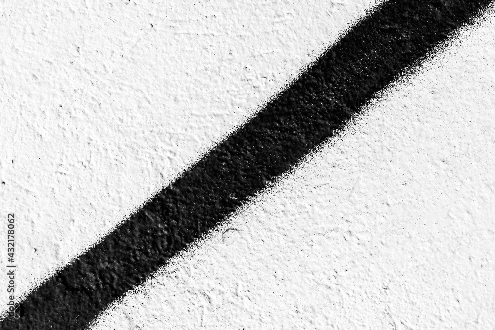 Rough white wall with black diagonal line. Close up view