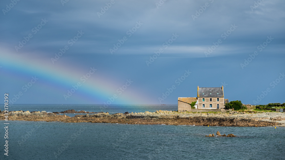 Rainbow over the sea and and old stone house