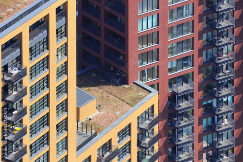 An aerial view taken from a helicopter of a new tower block in central London. The building contains many flats and homes with balconies looking across the capital city. 