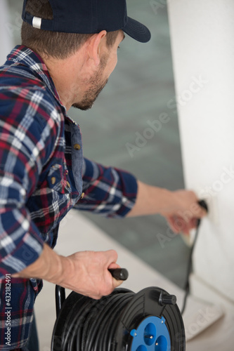 male electrician is holding an electric plug
