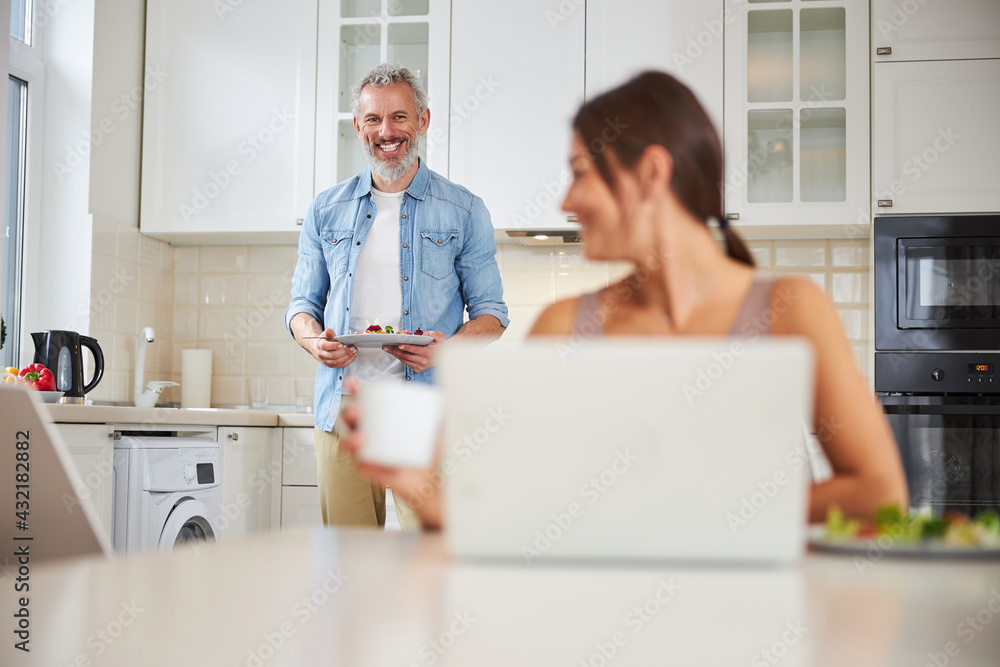 Fototapeta premium Handsome mature man carrying plate with salad