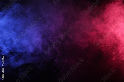 Artificial smoke in red-blue light on black background darkness