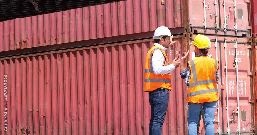 Hispanic man harbor worker talking on the walkie-talkie radio and control loading containers at container warehouse. container yard port of import and export goods Hispanic man harbor worker talking on the walkie-talkie radio and control loading containers at container warehouse. container yard port of import and export goods