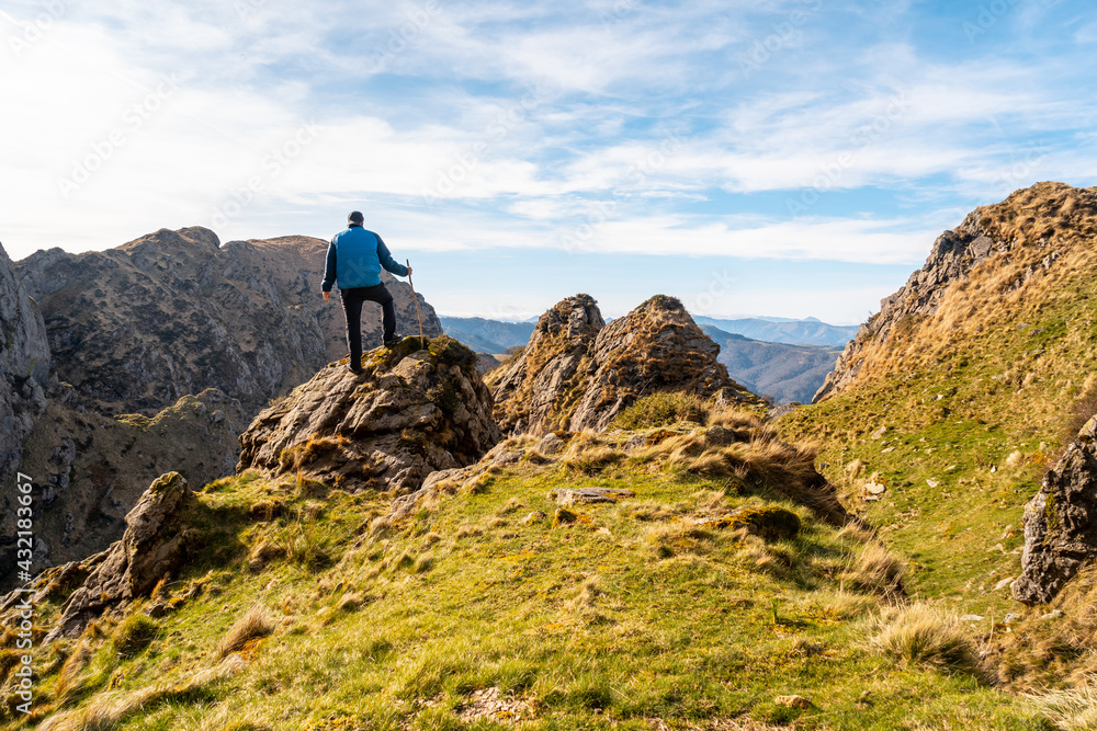 A hiker dressed in blue at the top of the mountain of Aiako Harria or Peñas de Aya in the town of Oiartzun, Guipúzcoa. Basque Country