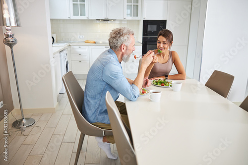 Positive delighted couple enjoying their healthy dinner