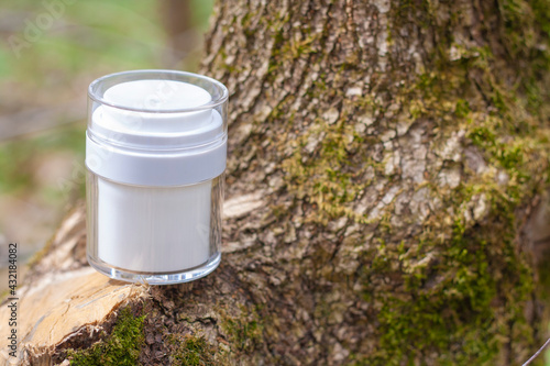 White jar with cosmetics on the bark of a tree in forest