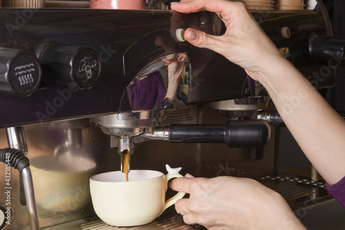 Barista hands prepare coffee in a cup in a small coffee shop. Small business concept