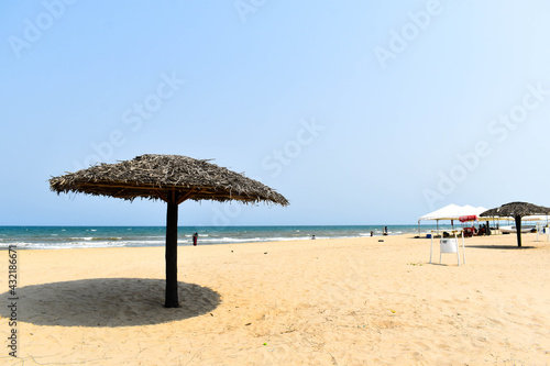 A beach with light blue sky   white sand and blue water