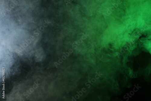 Artificial smoke in red-green light on black background