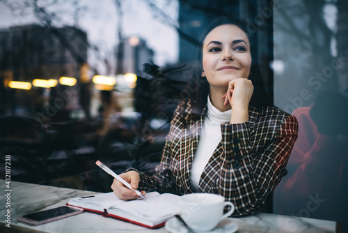 Photos Smiling woman with notebook in modern cafe