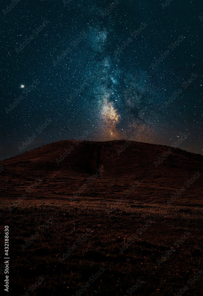 Milky way above dark landscape with Venus and colors 