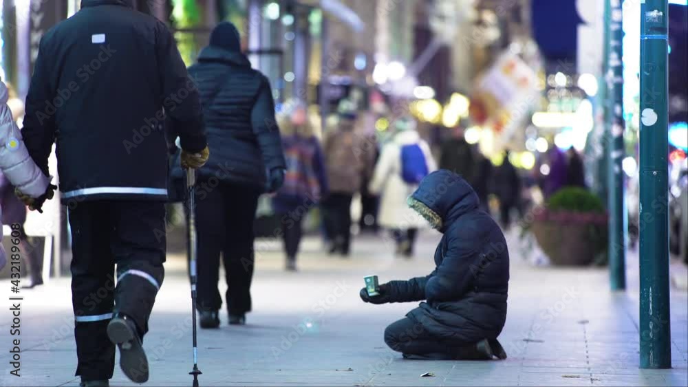 Unidentified homeless man begging on the street of European city winter Unidentified homeless man begging on the street of European city winter