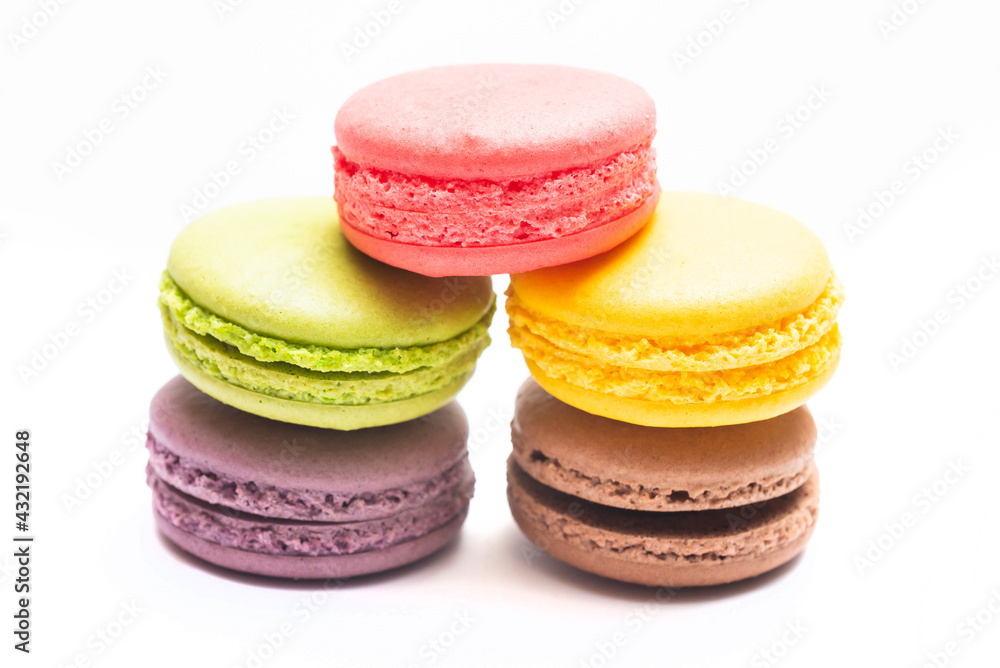 Various flavors of pastel macarons stacked against isolated on white background. Macarons is a delicate meringue-based cookie sandwich It is a dessert of French origin. Various flavors of pastel macarons stacked against isolated on white background. Macarons is a delicate meringue-based cookie sandwich It is a dessert of French origin.