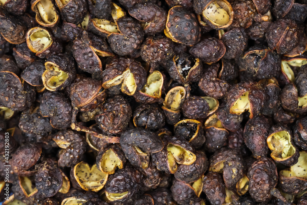 Macro full frame closeup of raw brown whole chinese sichuan timut pepper corns with citrus anise taste Macro full frame closeup of raw brown whole chinese sichuan timut pepper corns with citrus anise taste