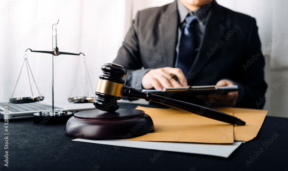 Business and lawyers discussing contract papers with brass scale on desk in office. Law, legal services, advice, justice and law concept picture with film grain effect Business and lawyers discussing contract papers with brass scale on desk in office. Law, legal services, advice, justice and law concept picture with film grain effect