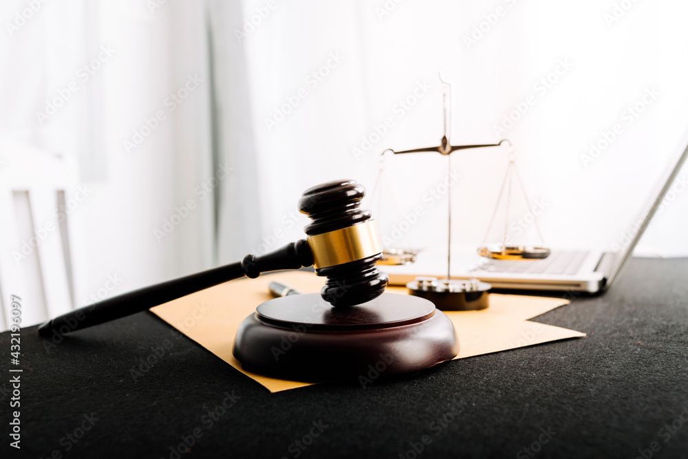 Business and lawyers discussing contract papers with brass scale on desk in office. Law, legal services, advice, justice and law concept picture with film grain effect Business and lawyers discussing contract papers with brass scale on desk in office. Law, legal services, advice, justice and law concept picture with film grain effect
