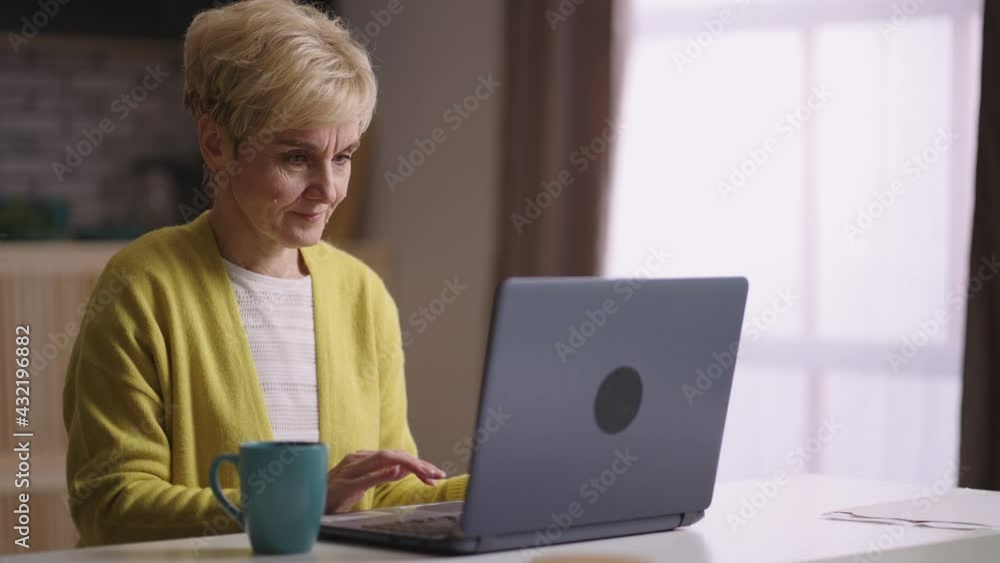 elderly woman is typing and sending message by laptop, communicating in social nets, surfing internet and browsing sites elderly woman is typing and sending message by laptop, communicating in social nets, surfing internet and browsing sites