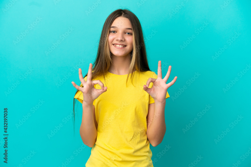 Little girl over isolated blue background showing ok sign with two hands Little girl over isolated blue background showing ok sign with two hands