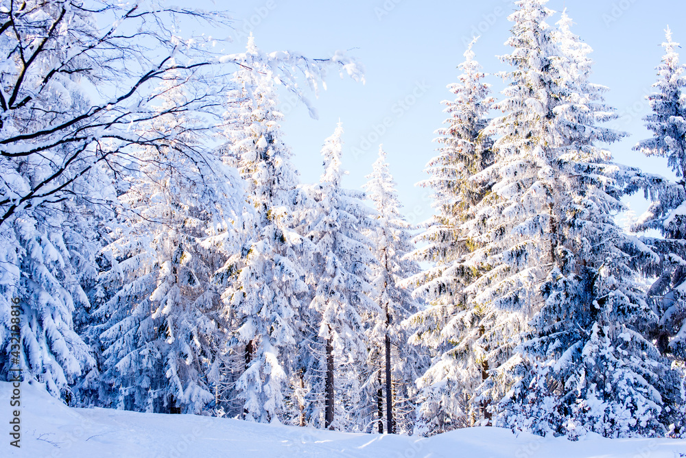 Beautiful winter landscape. Mountains in winter. The forest is covered with snow. Landscape for poster.Snowdrifts on winter snow covered mountainside and sun shine in blue sky. Beautiful winter landscape. Mountains in winter. The forest is covered with snow. Landscape for poster.Snowdrifts on winter snow covered mountainside and sun shine in blue sky.